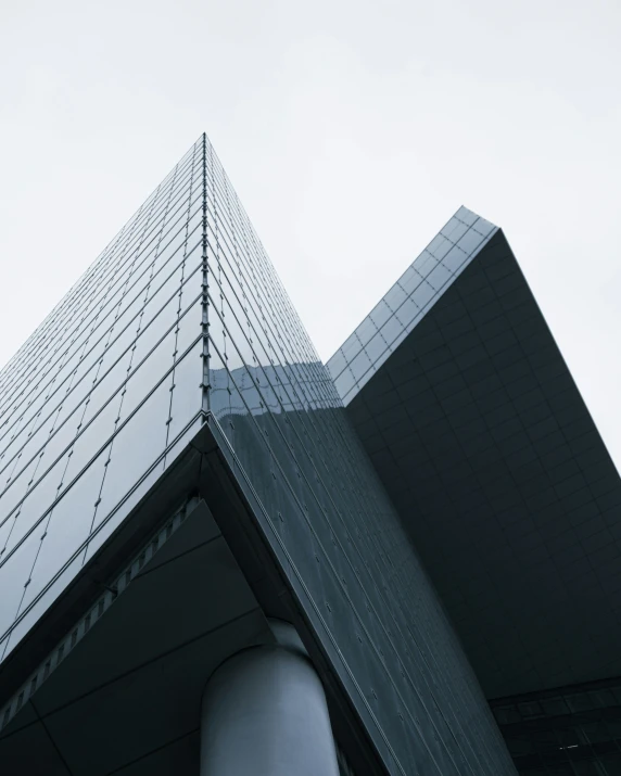 a tall, triangular building is next to a curved corner