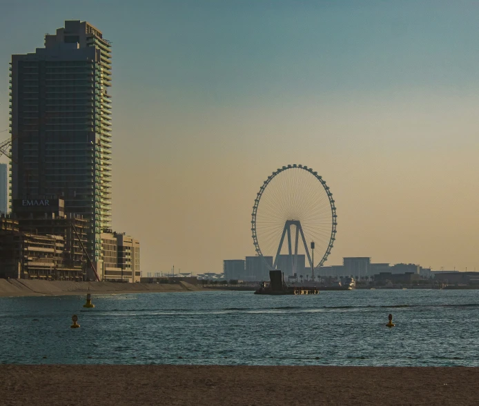 the cityscape shows ferris wheel as it passes by on the water