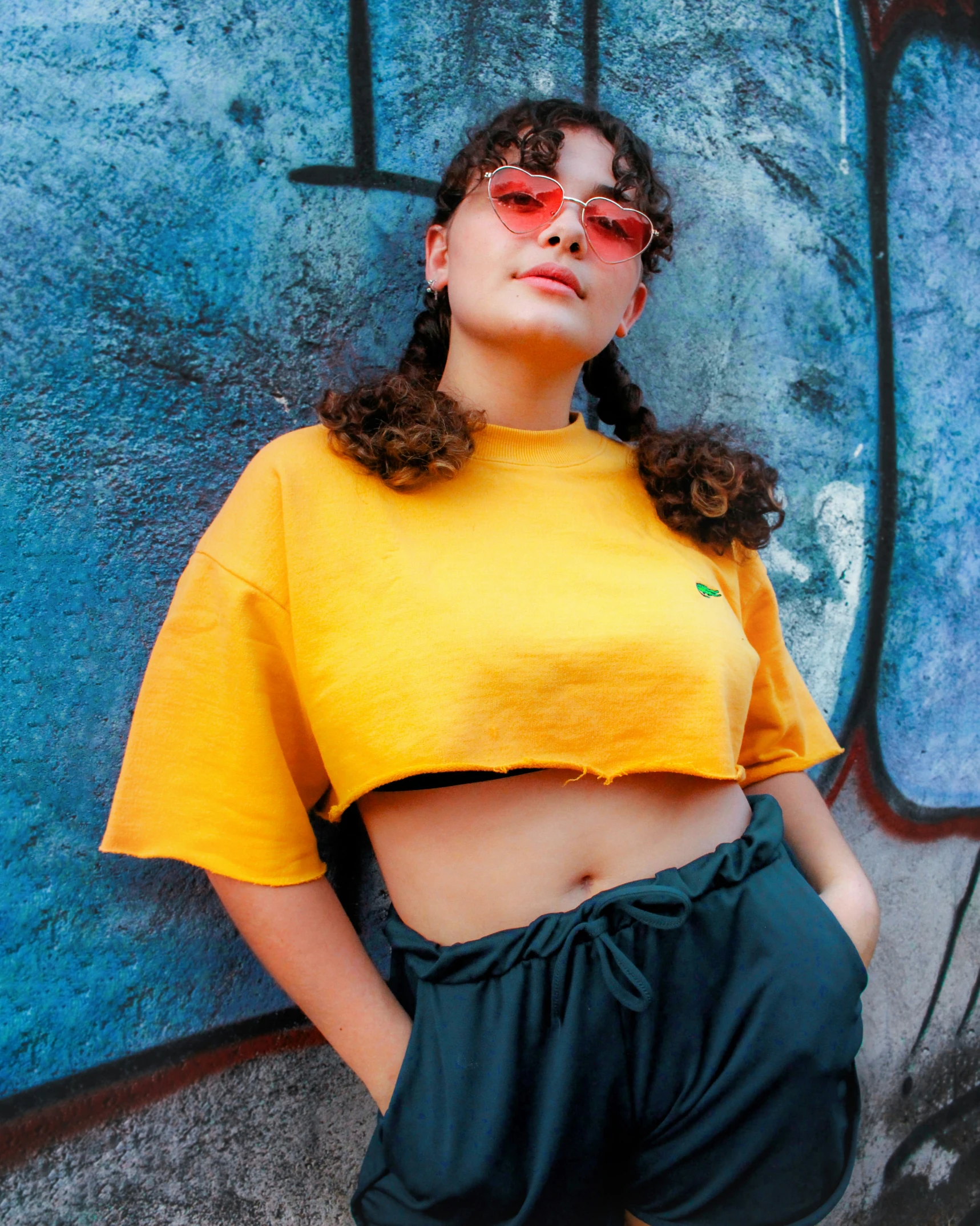 a woman wearing a yellow top and shorts posing