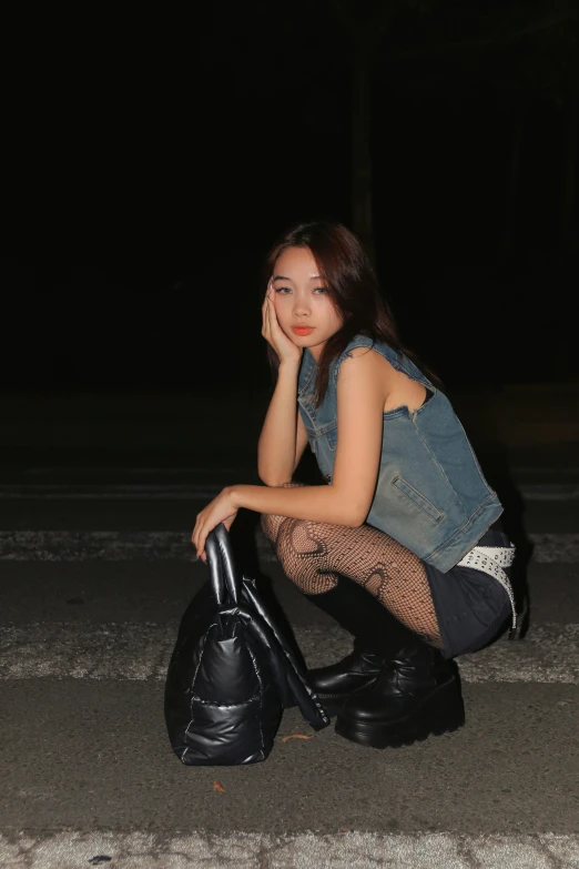 an attractive woman kneeling down with a purse