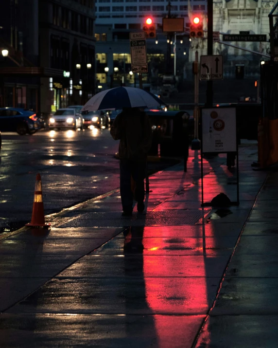 people are walking on the sidewalk at night