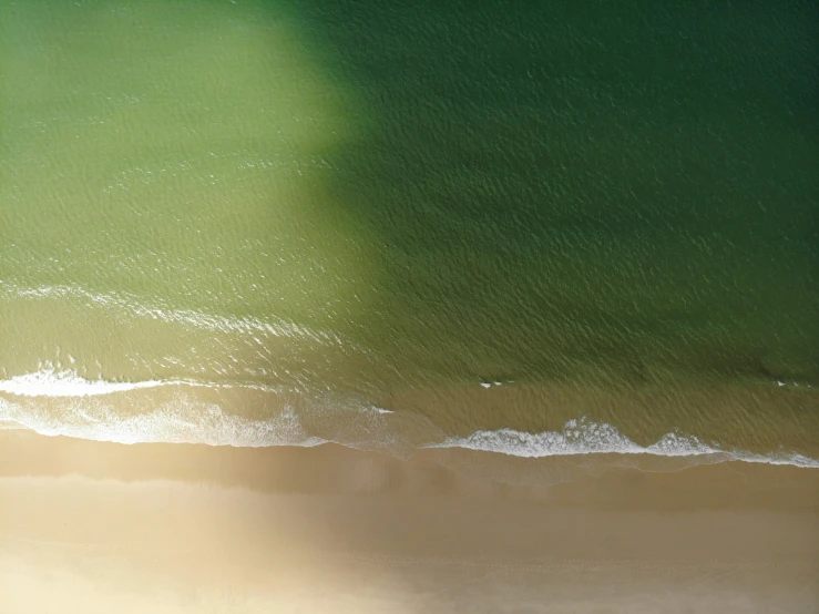 a beach with green water and some waves