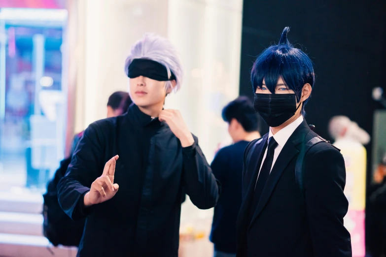 two guys dressed up in face masks and one man with a gray wig