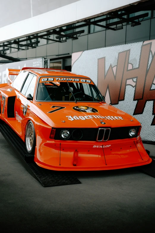 an orange car is parked on the asphalt