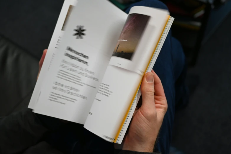 someone holding a manual in their hands with a computer in it