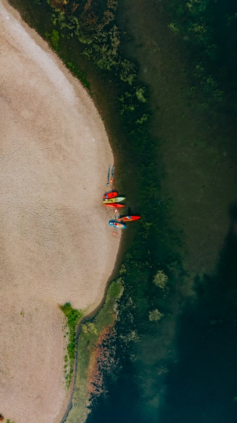 a group of canoers in their canoes on the shore