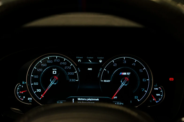 a close up of an illuminated vehicle's dashboard with meter