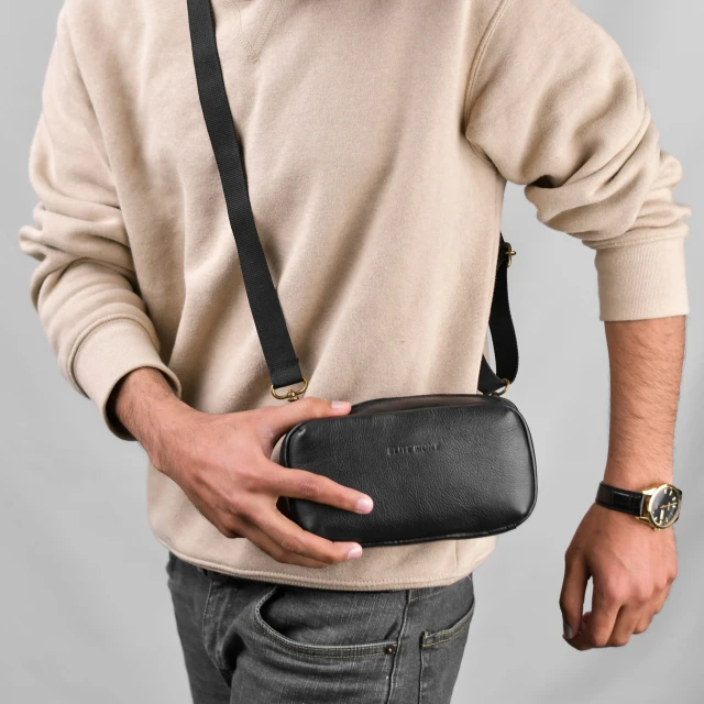 a man with glasses holding a black bag