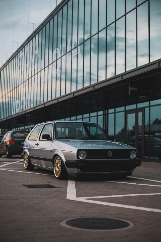 silver car parked in front of glass building