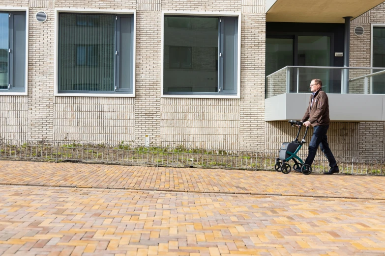 a man in brown coat with a bicycle outside of a building