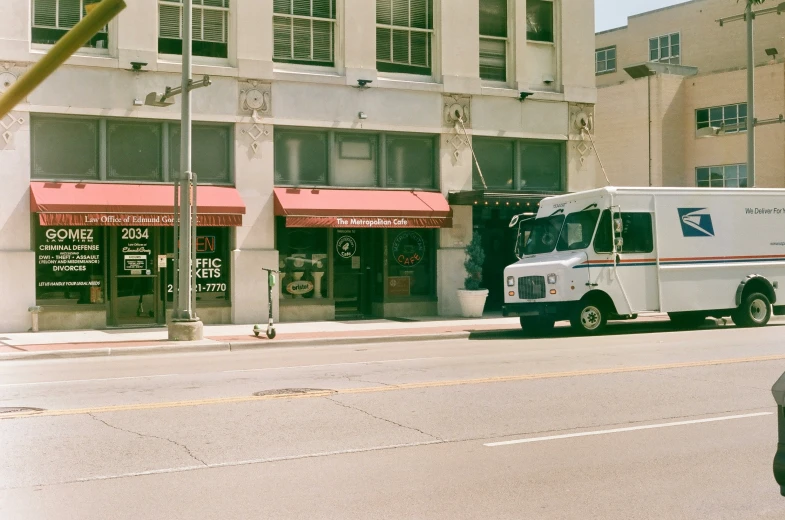 an postal service truck on the side of the street