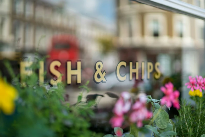 a fish and chips shop with flowers in front of it