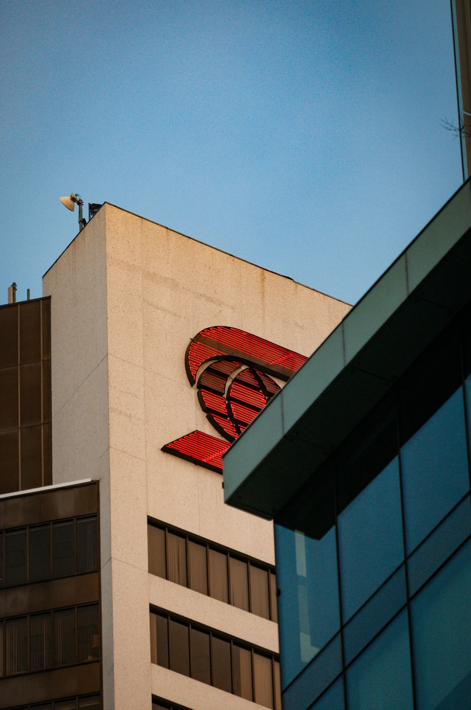 large red bird on top of the corner of a building