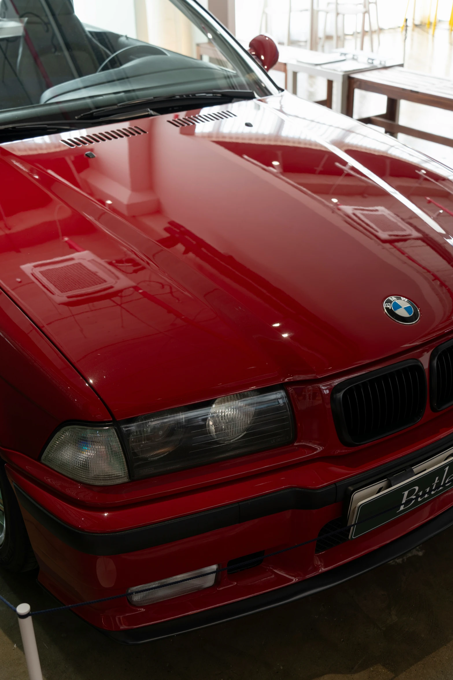 a red bmw car in a display area