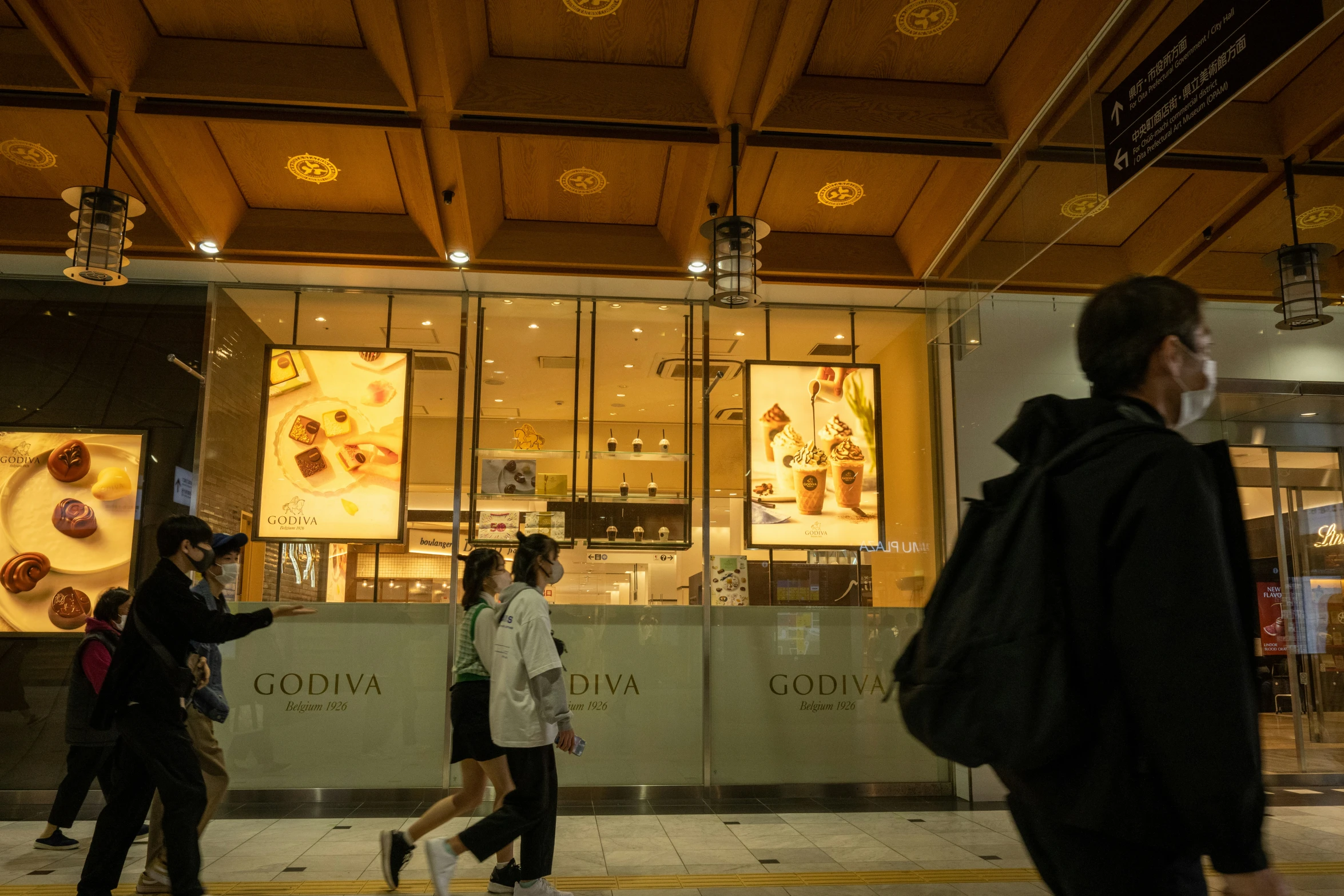 people walking along a city street in front of a store