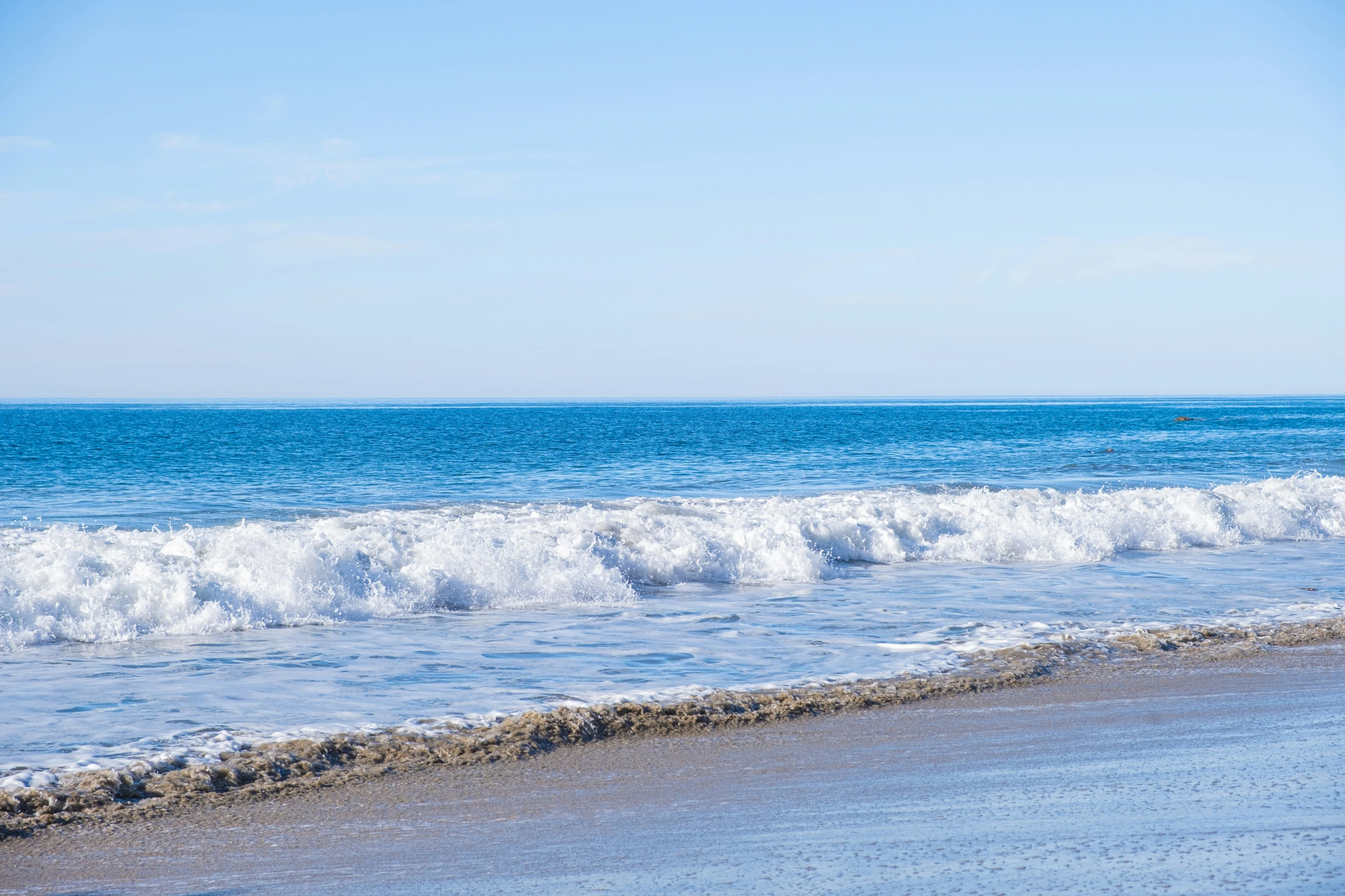 a view of a sea beach with white waves