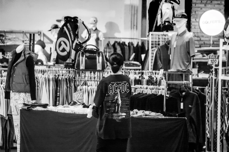 the black and white po shows a man in front of many clothes