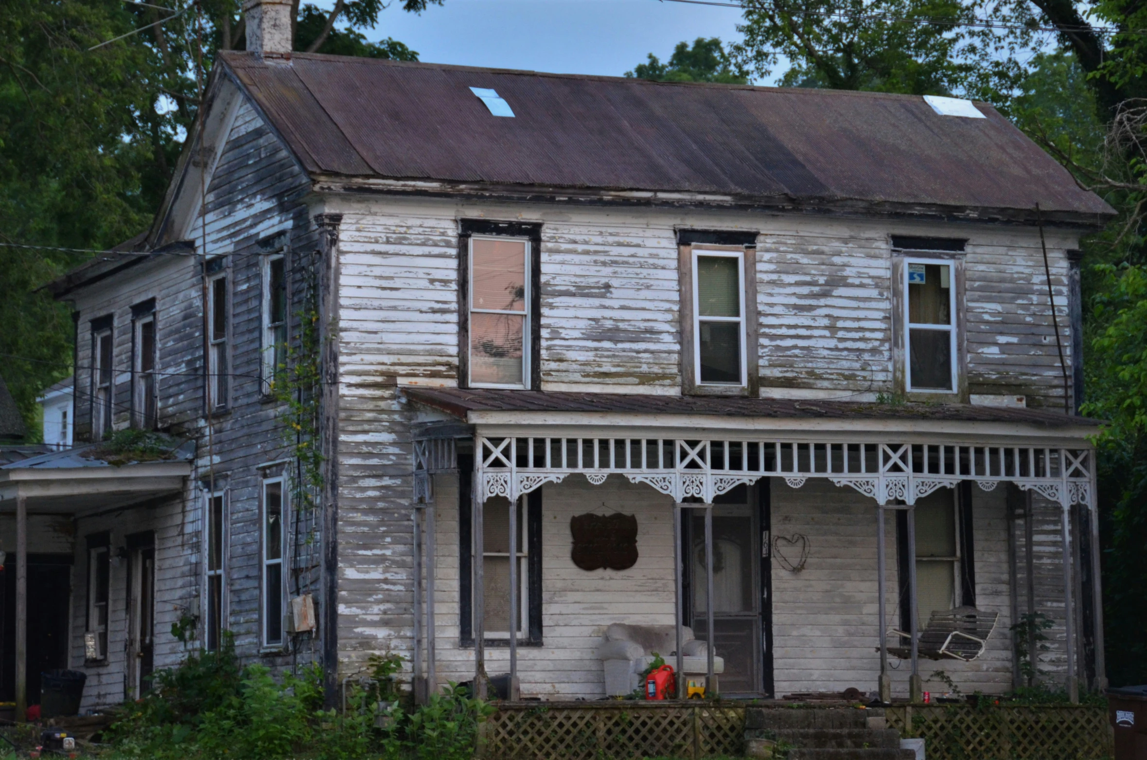 an old house with a very large window and small front porch