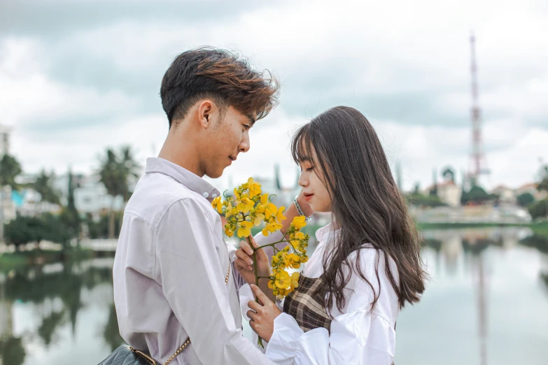 a man is holding flowers and standing next to a woman