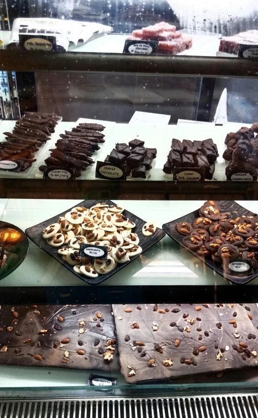 various kinds of pastries and desserts in a glass case