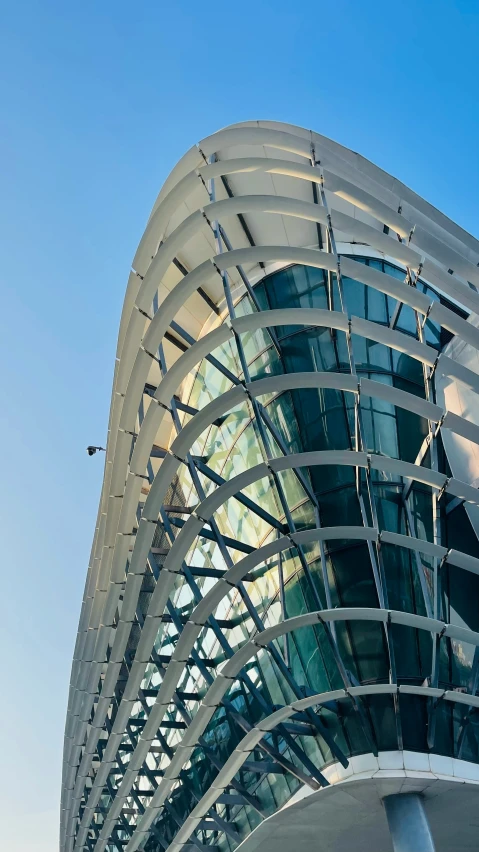 the roof of a glass structure against a blue sky