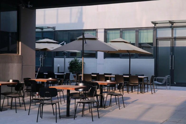 the restaurant has a lot of tables, chairs and umbrellas