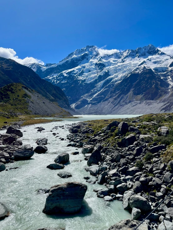 rocky area with small body of water and mountains in the distance