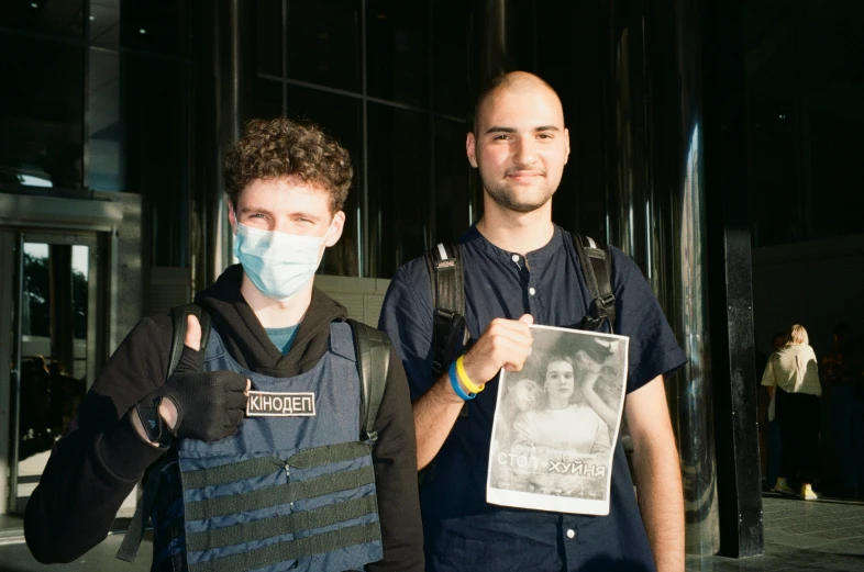 two men are holding up a piece of paper