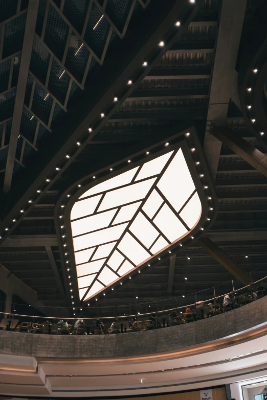 a large suspended beam at an auditorium full of people