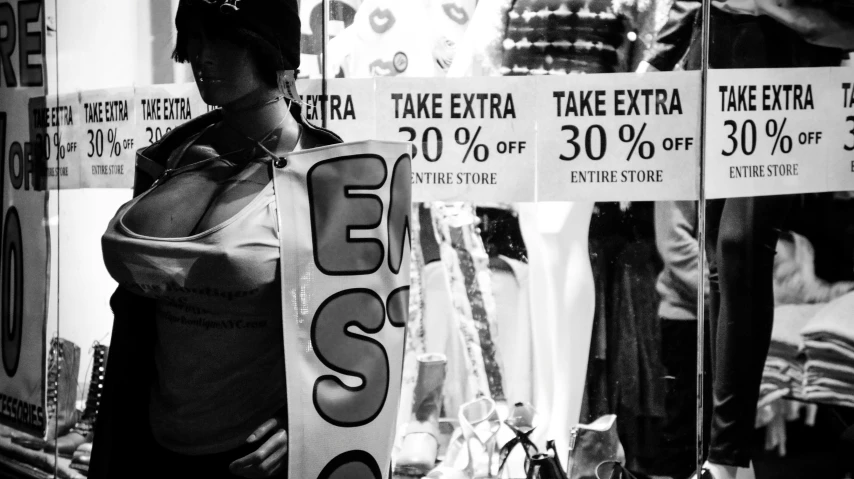 black and white po of woman holding shopping sign