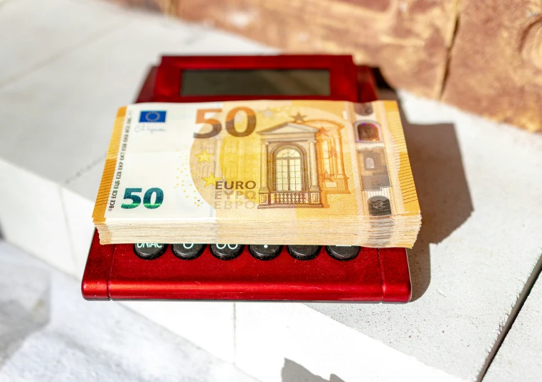 an old wooden type electronic device covered with 50 euros bills