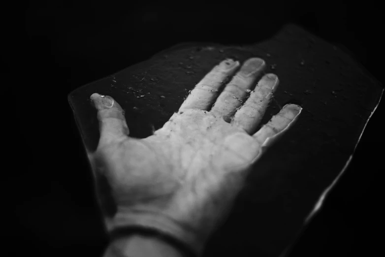 a person's hand holds the surface of a wooden structure