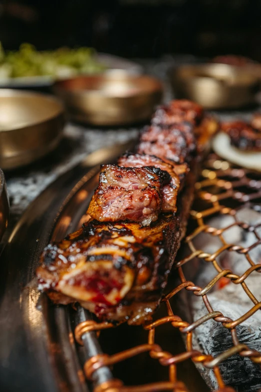 a long plate with meat on it next to some bowls