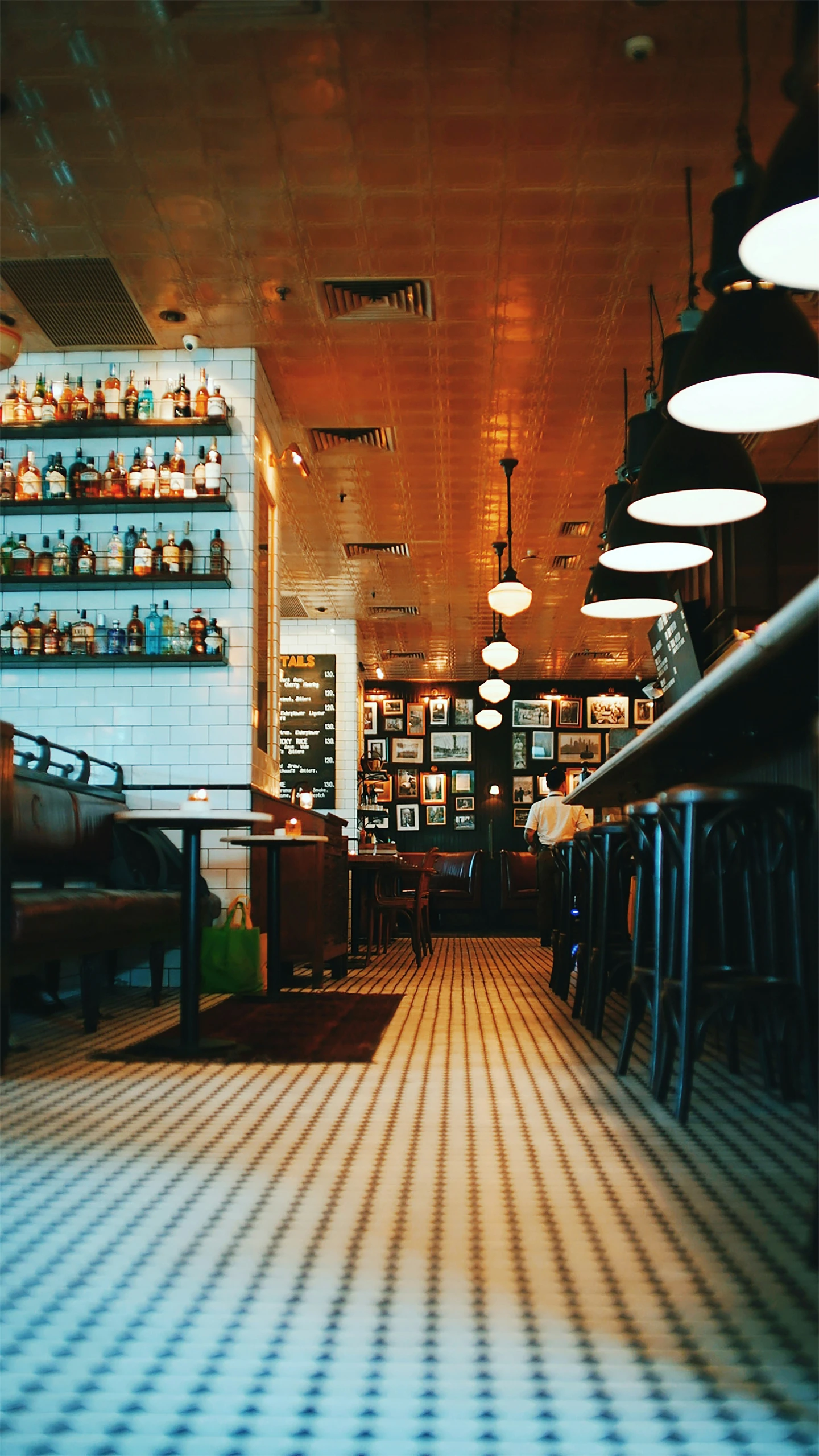 a dimly lit restaurant that has checkered tiles on the floor