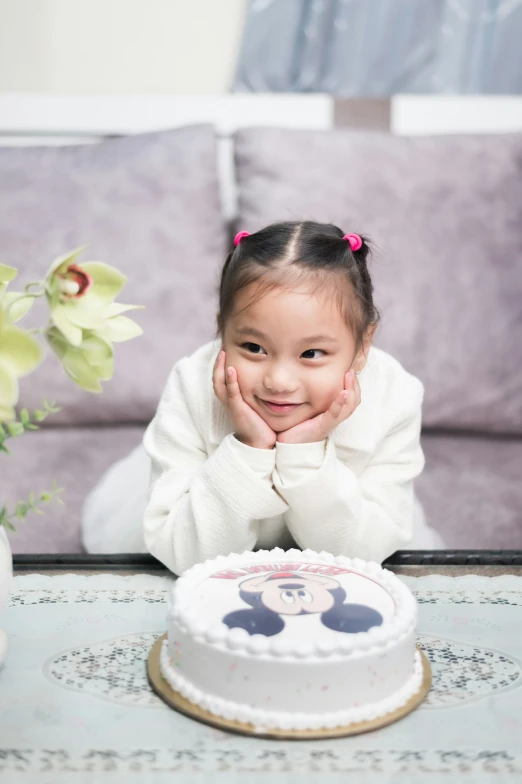 the little girl is posing in front of her cake