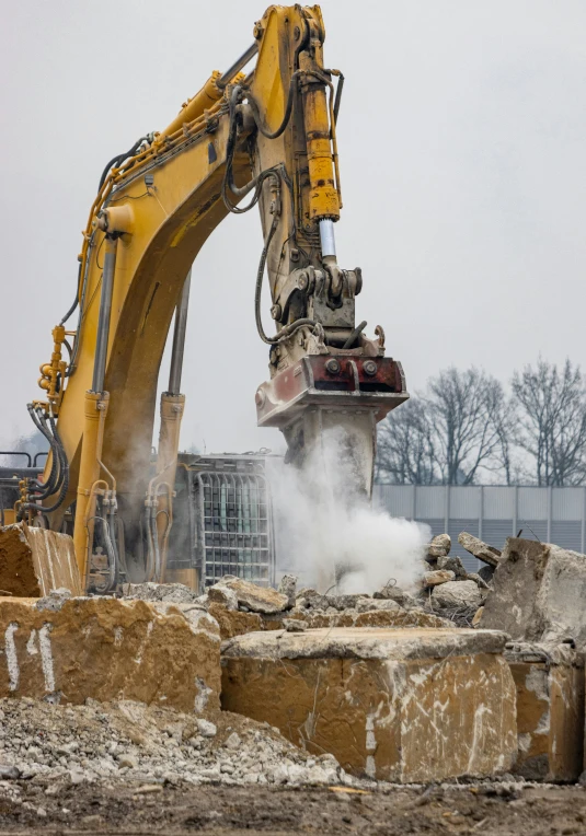 a demolition crane is next to a pile of rubble