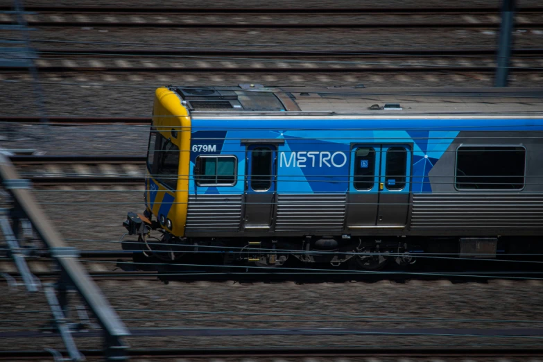 the metro train is moving through an area with brown and blue tracks