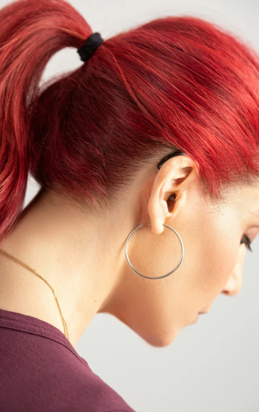 woman with a large silver hoop earring on top of her head