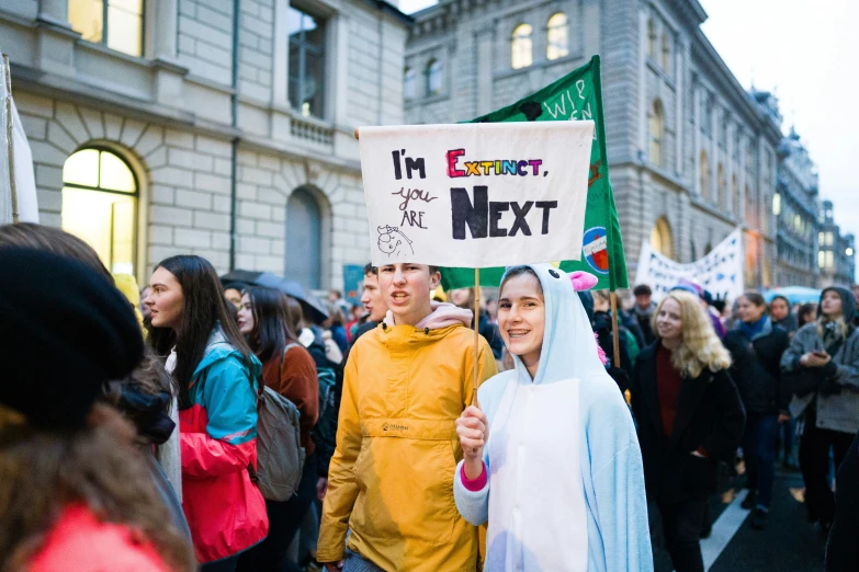 people on a street holding signs with a woman holding a banner
