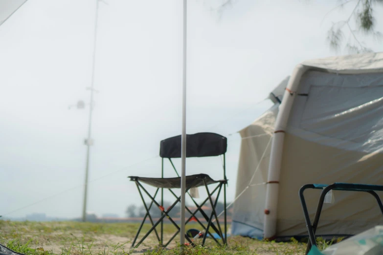 there is a chair next to the tall flag pole