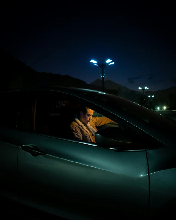 a man sits in his car at night