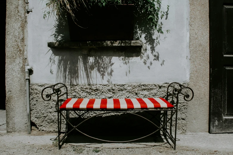 a bench and window near the wall with plants