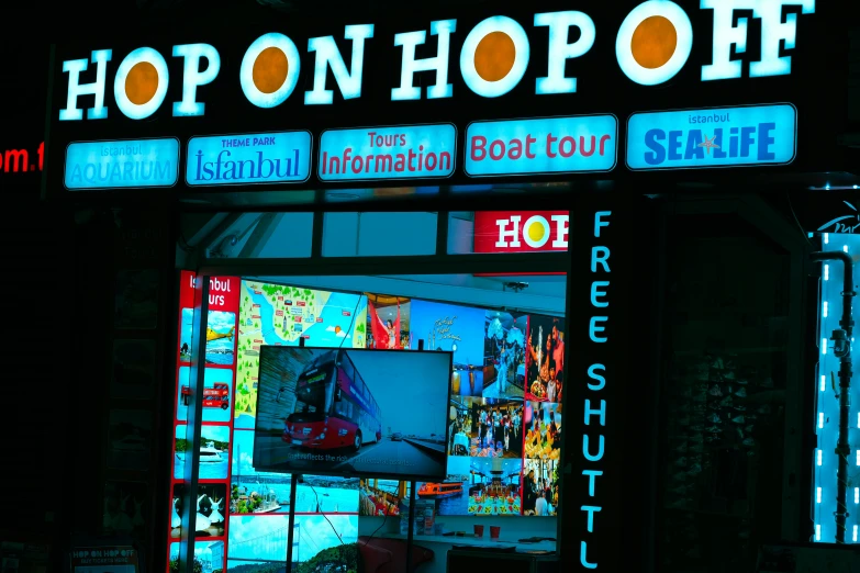 a neon sign that reads hop on shop off in the night