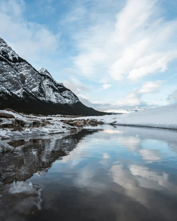 a very pretty body of water in a big snowy landscape