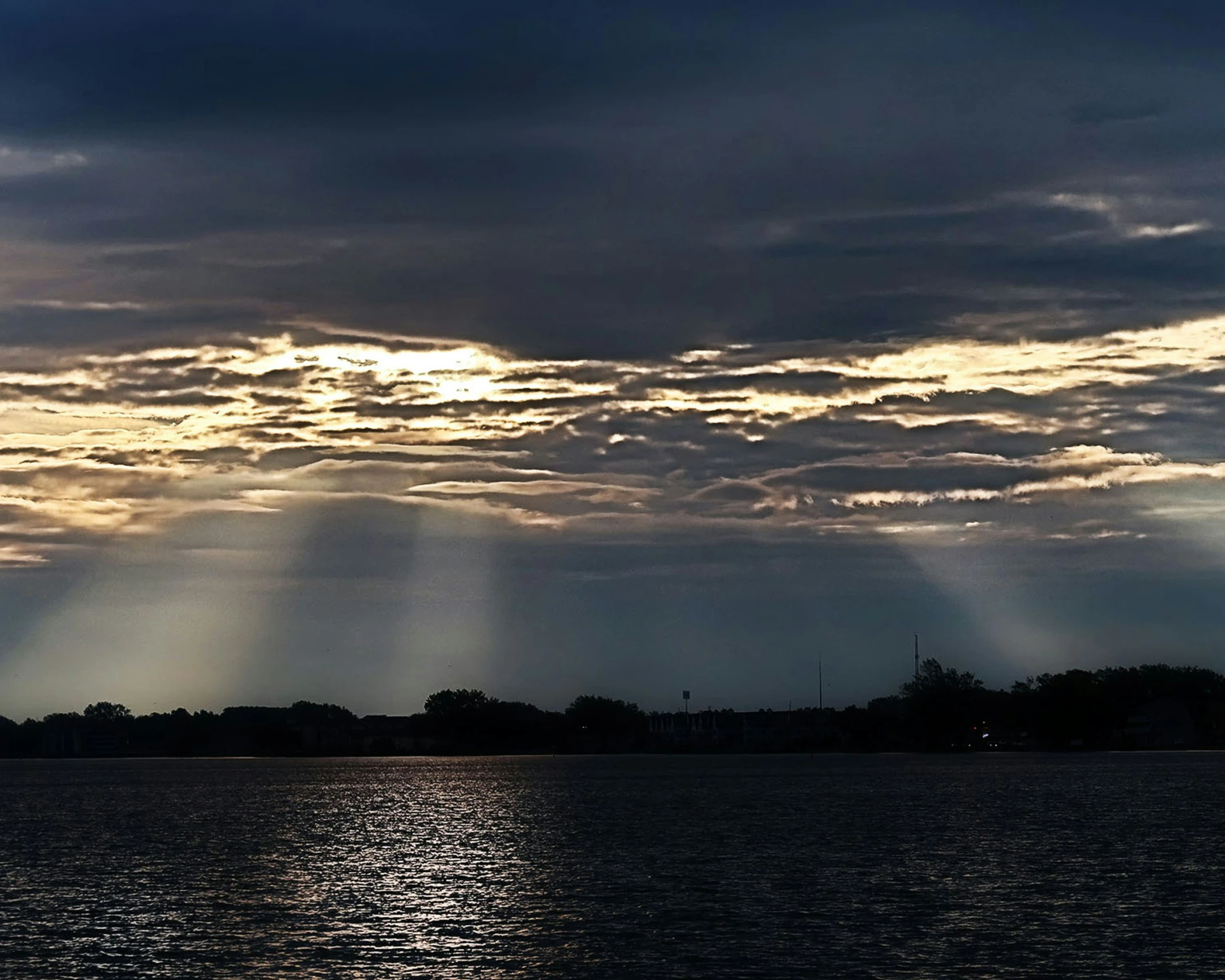 sunlight beaming through clouds and reflecting in the water