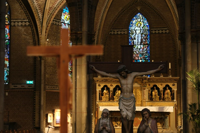 a statue of jesus is placed behind two other sculptures