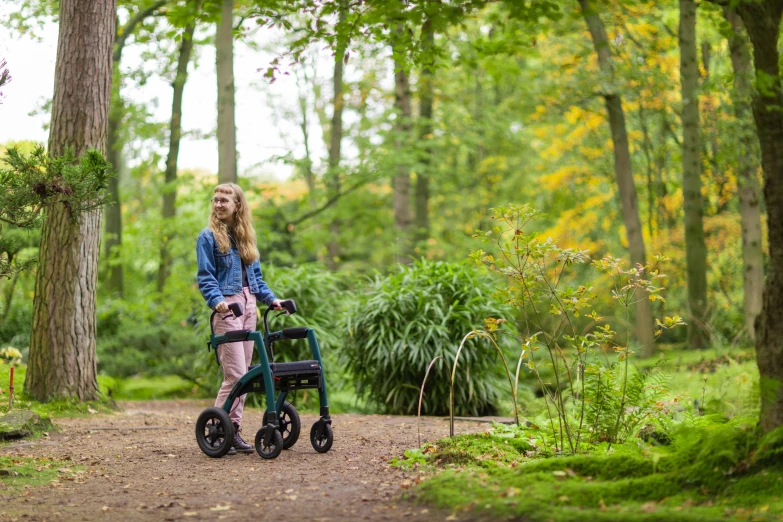 a person walking down a dirt road with a stroller on it