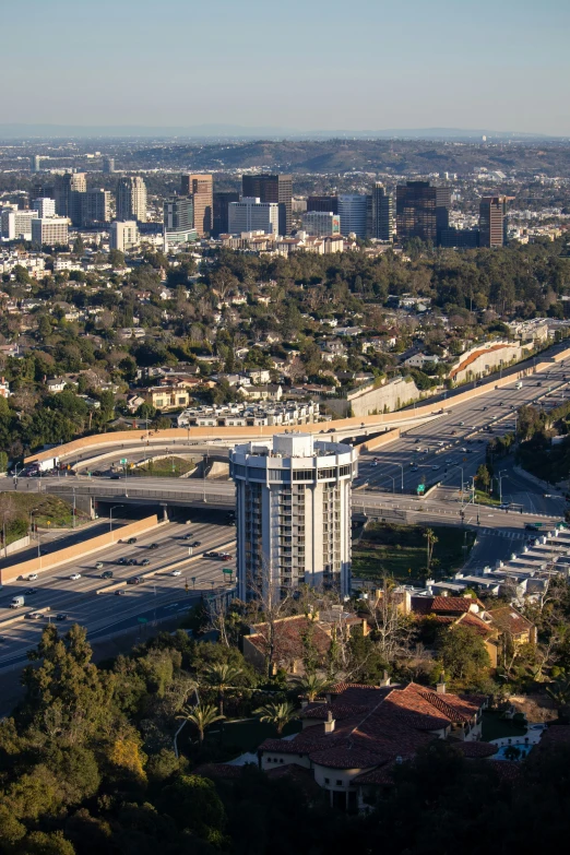 a city skyline with two roads going through it and some buildings in the background