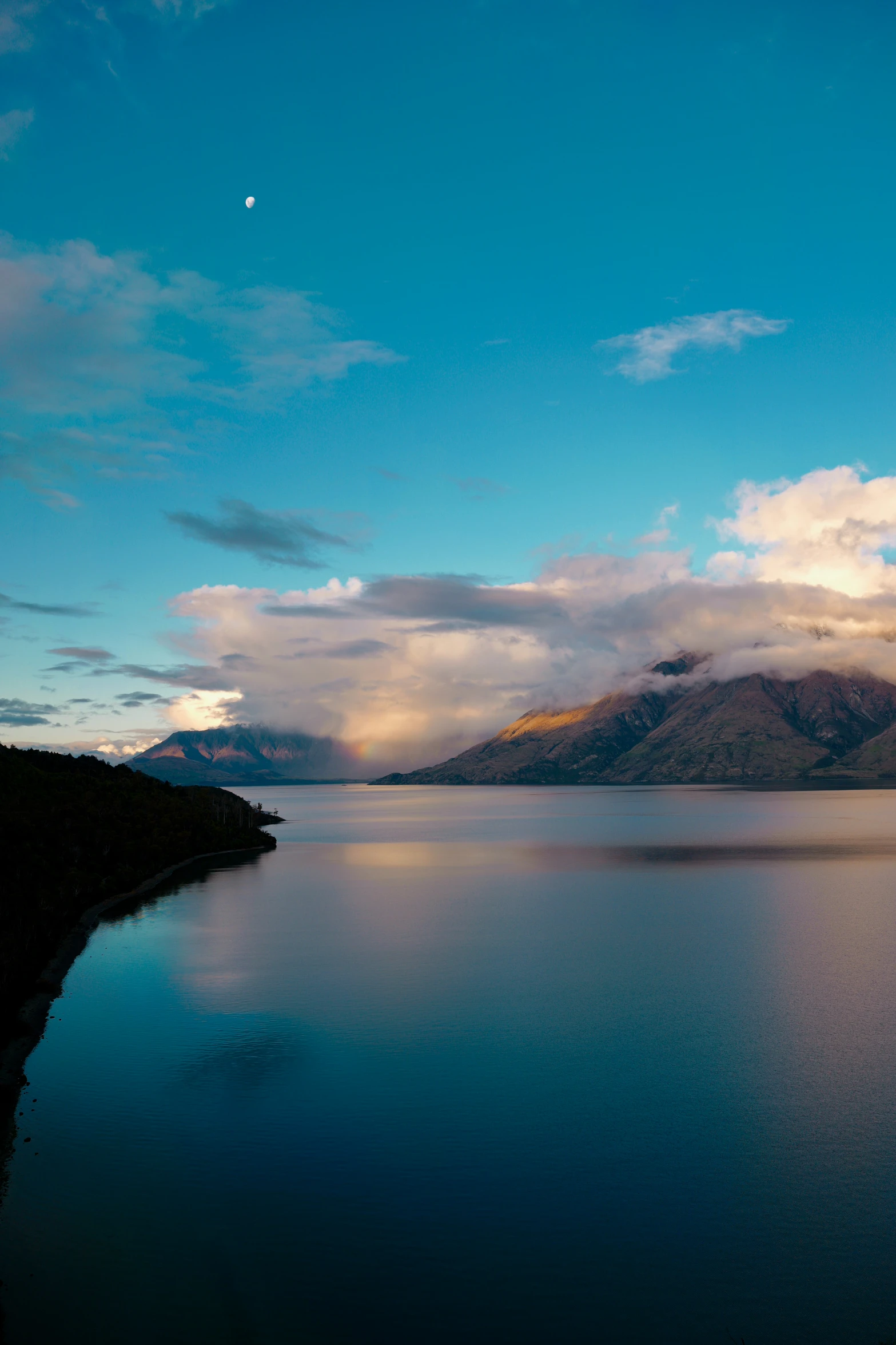 water with mountains in the background during sunset