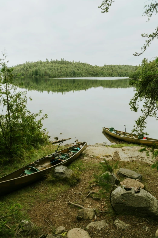 a small body of water with two canoes next to it